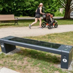 woman-jogging-with-baby-in-stroller-technology-enabled-park-bench-in-the-foreground