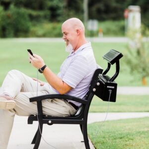 man-sitting-on-technology-enabled-park-bench-checking-his-cell-phone