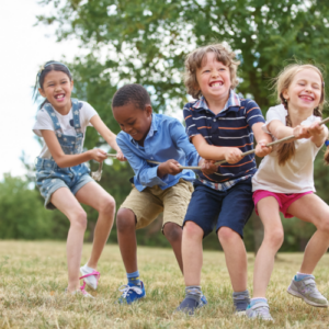 four children pulling a rope in a park