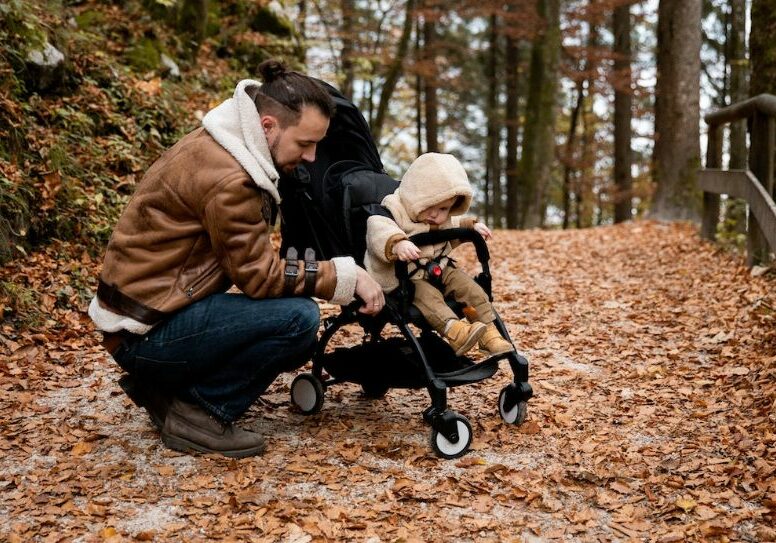 Man with child in stroller on a trail